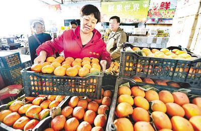日前,市果品批发市场扶贫馆专卖区的商户在整理果品.